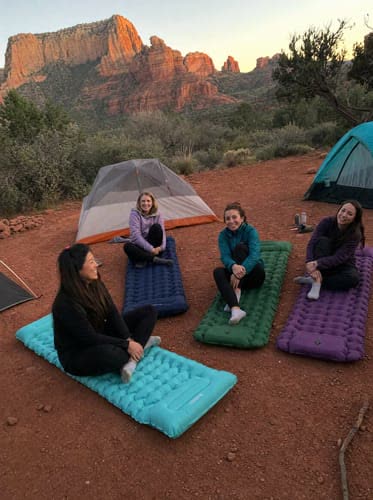 Customer photo: four friends on four different coloured Uskoo AirFlex pads at a Sedona campsite