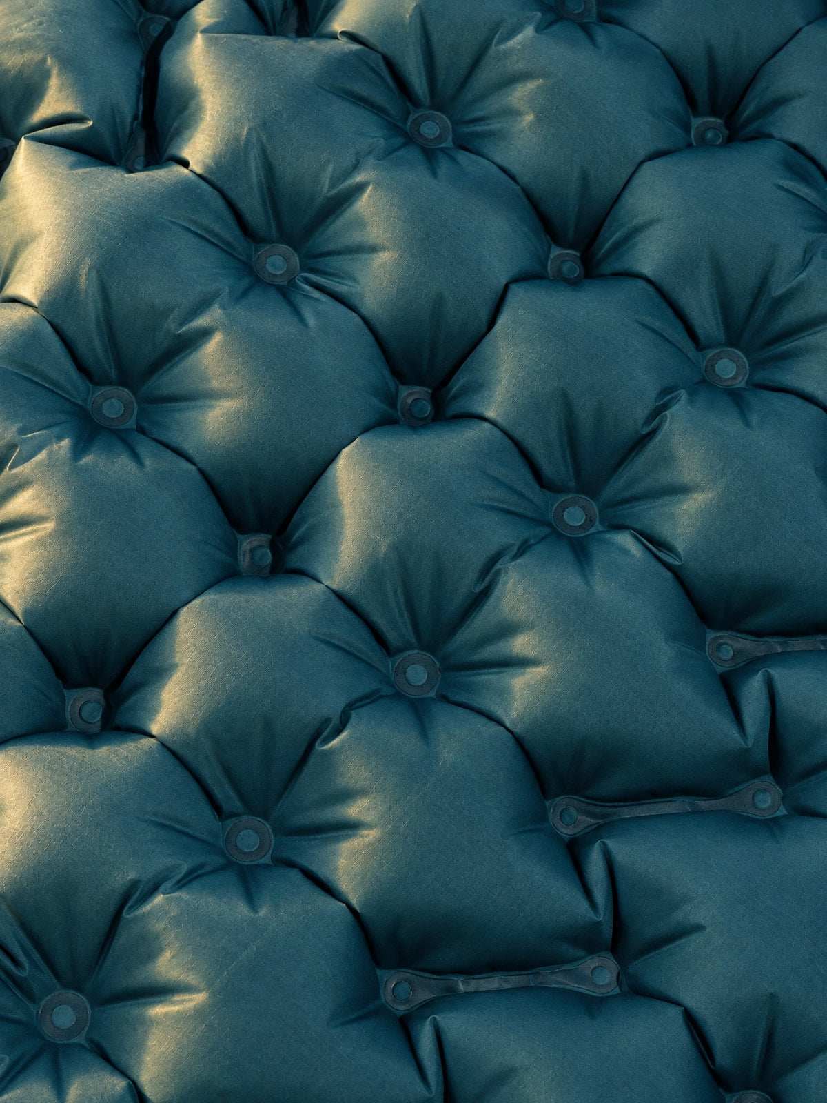 Close-up of the AirFlex air cells in turquoise, each one welded in a star pattern, in low morning light